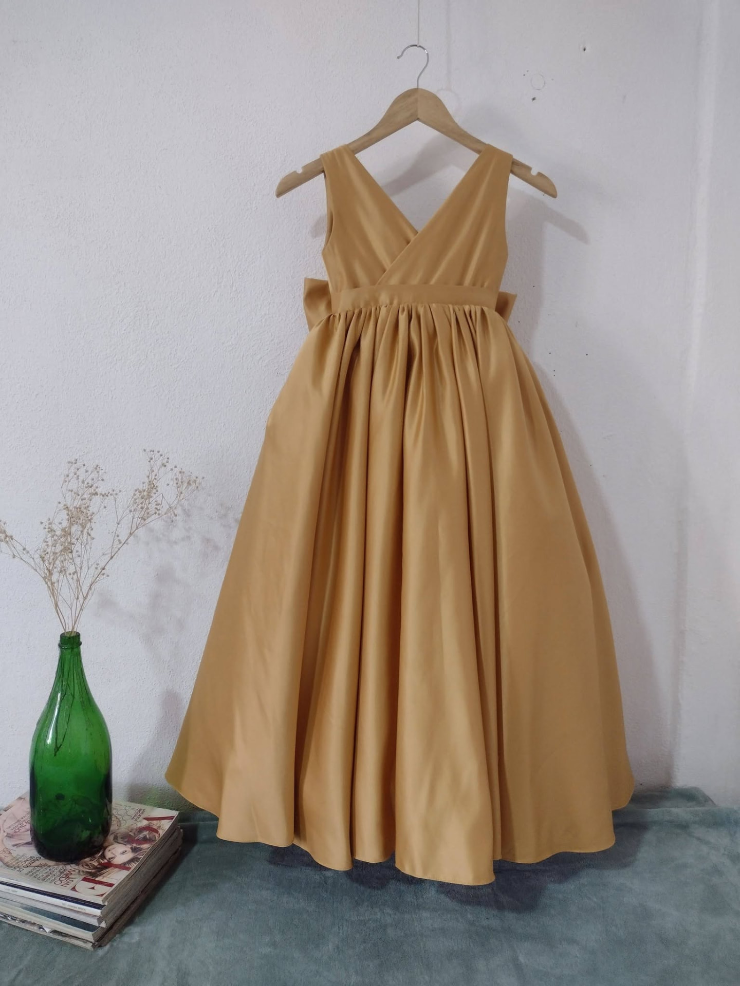 Vestido dorado terminado colgado en el taller